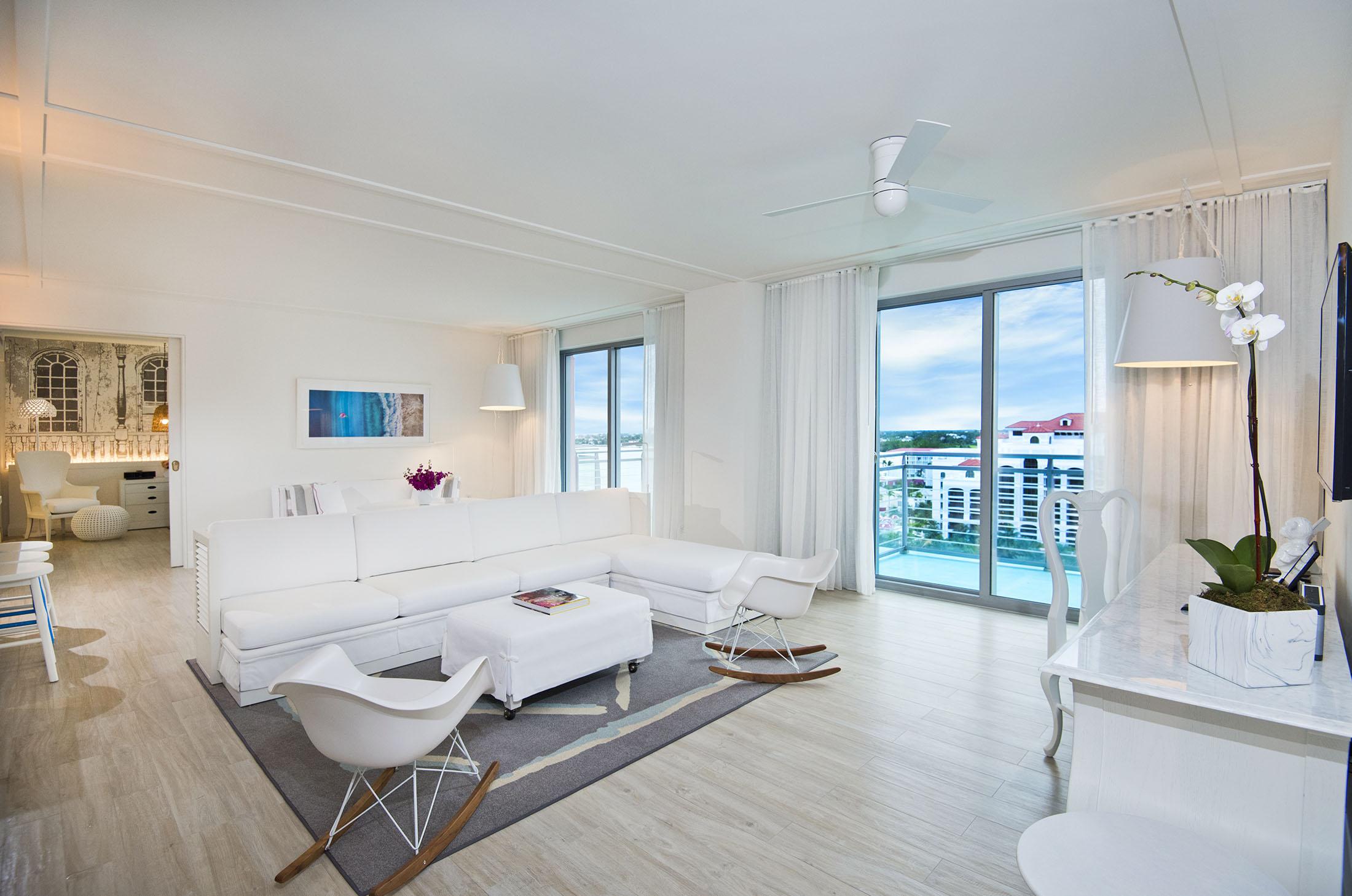 흰색 소파와 의자가있는 호텔 방 거실 공간
