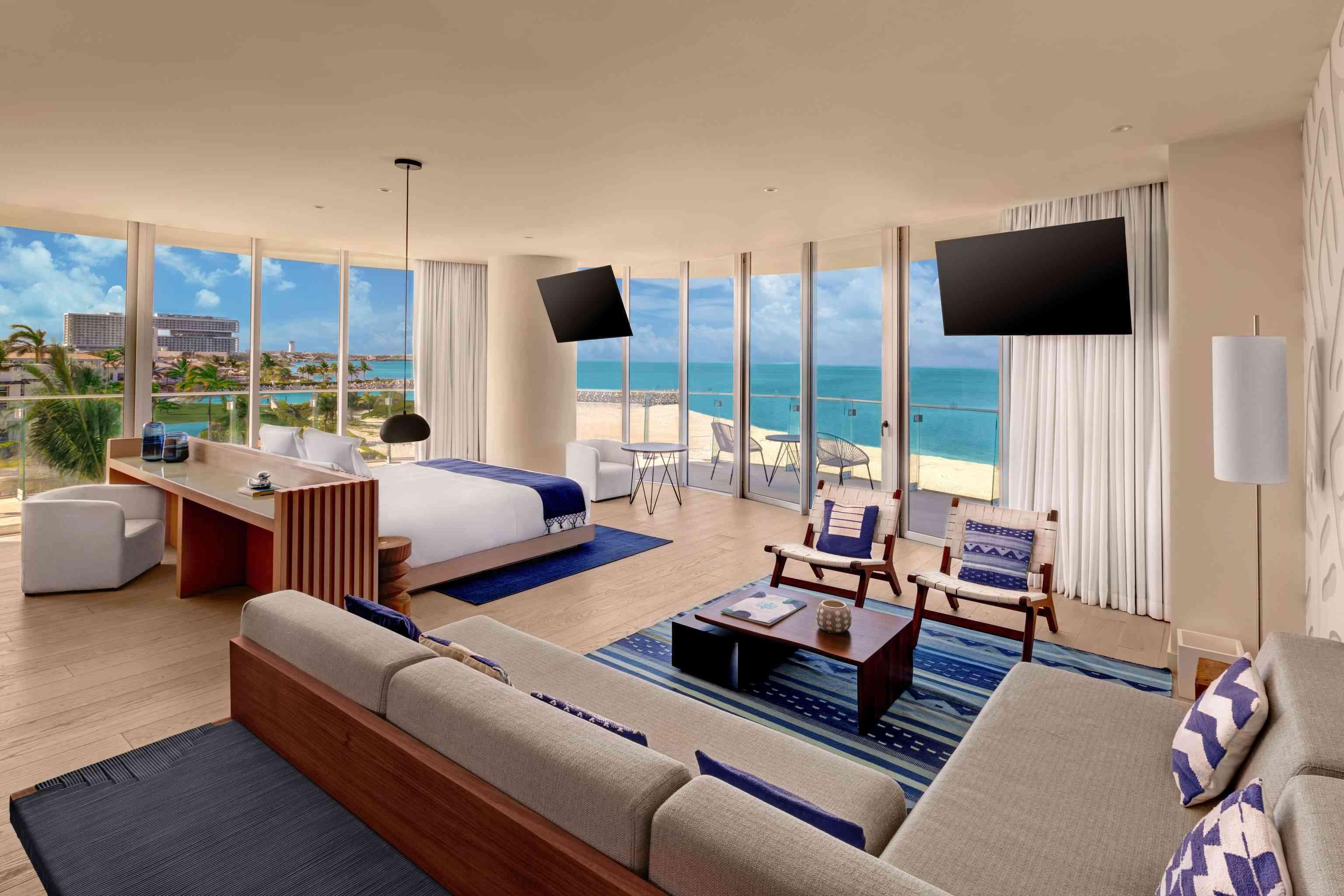 책상, 넓은 휴식 공간, TV 2대, 침대, 바다 전망의 발코니가 있는 프리미어 오션 프런트 1베드룸 스위트의 와이드 샷
